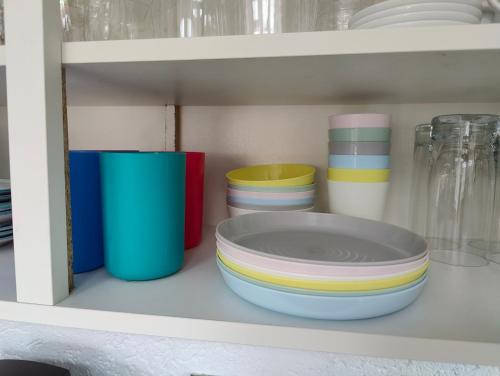 a shelf with colorful bowls and plates on it at Ferienwohnung Biene in Saarbrücken
