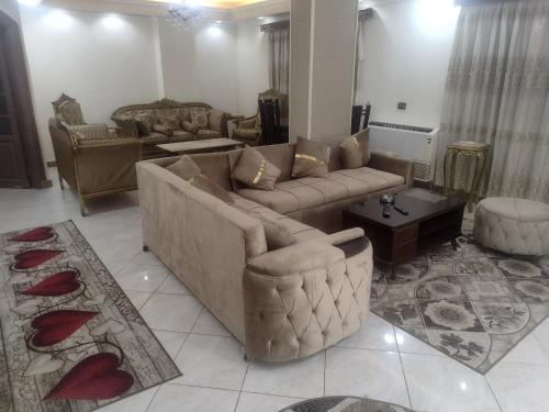 uma sala de estar com um sofá, cadeiras e uma mesa em القاهره no Cairo