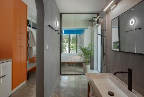a bathroom with a large sink and a bedroom at Adrop Pool Suites in Paphos