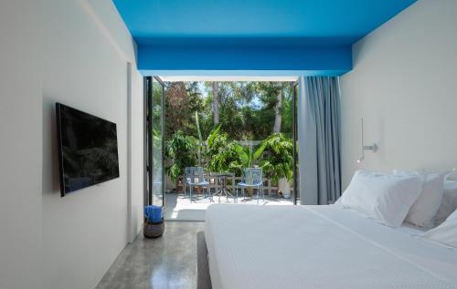 a bedroom with a bed and a view of a patio at Adrop Pool Suites in Paphos