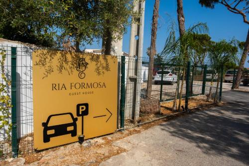a yellow sign on a fence with a parking meter at Ria Formosa Guest House in Faro