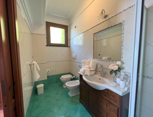 een badkamer met een wastafel, een toilet en een spiegel bij Casa Armeno a Ravello in Ravello