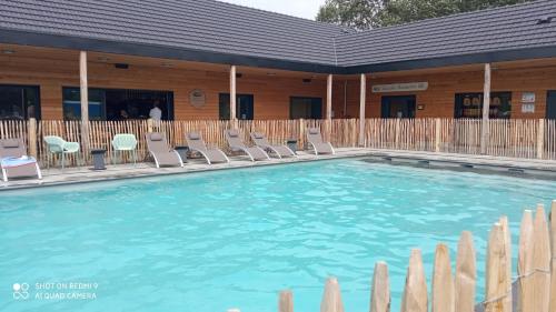una grande piscina con sedie e un edificio di Villa du chemin des Anglais a Berck-sur-Mer
