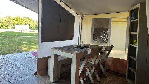 - une terrasse couverte avec une table et des chaises dans l'établissement TENTE LODGE la Plage AUTET, à Autet