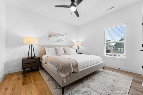 a white bedroom with a bed and a ceiling fan at Moonlight Manor home in Hollister