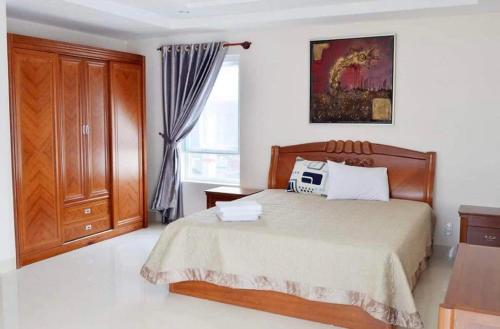 1 dormitorio con 1 cama, vestidor y ventana en Natural An Viên Villa, en Nha Trang