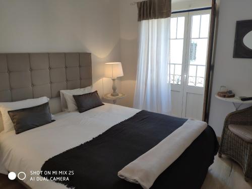 a bedroom with a large bed and a window at Casa da Tia Amalia in Mértola