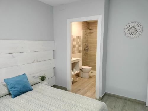 een slaapkamer met een bed en een badkamer met een toilet bij Posada de la plata in Valdesalor