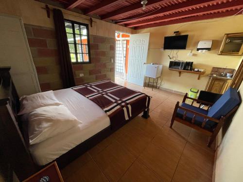 1 dormitorio con 1 cama y 1 silla en una habitación en Cabañas Guadalupe Volcán, en Volcán