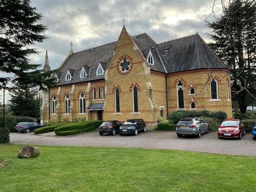 Magical Church Conversion in Watford في واتفورد: كنيسة فيها سيارات متوقفة امامها