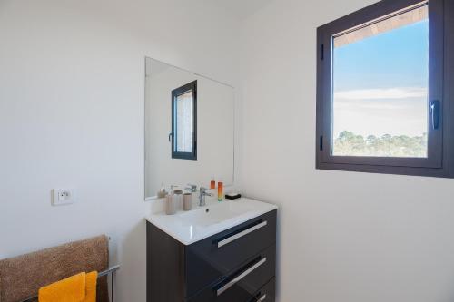une salle de bain avec un lavabo et une fenêtre dans l'établissement Villa TRA -pisc chauffée-8 pax, à Lecci