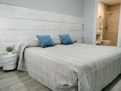 een slaapkamer met een groot bed met blauwe kussens bij Posada de la plata in Valdesalor