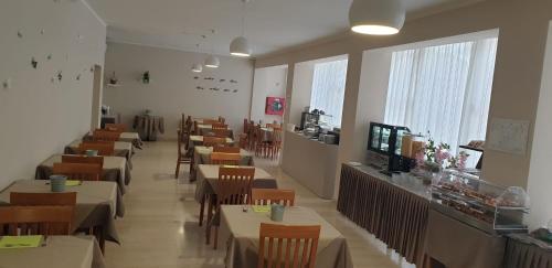 a dining room with tables and chairs and a counter at Hotel Cimarosa in Riccione