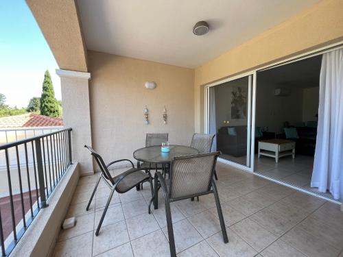 un balcón con mesa y sillas. en Cozy Apartment in Paphos Beautiful Complex, en Pafos