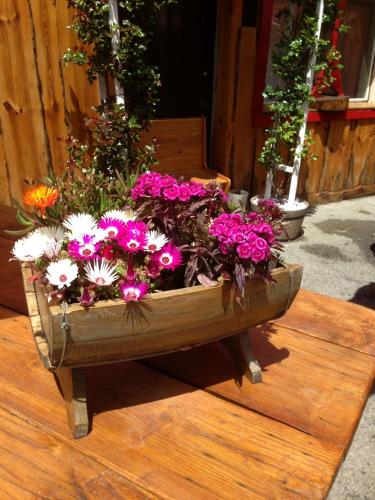 a wooden planter filled with pink and white flowers at La Godille in Andon