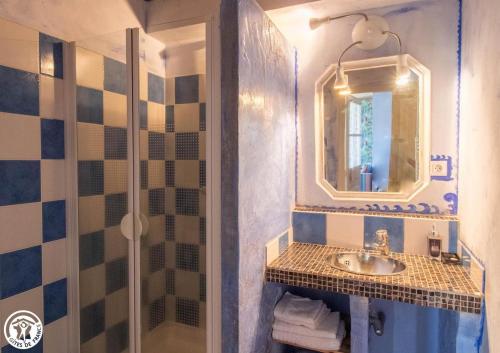 une salle de bain avec un lavabo et une douche avec un miroir dans l'établissement La maison des archers, à Saint-Saturnin