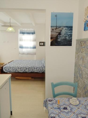 a bedroom with a bed and a chair and a table at La casa di Uccia in Trieste