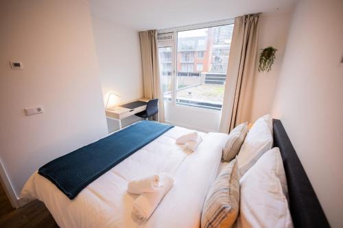 sypialnia z dużym łóżkiem z ręcznikami w obiekcie Delightful 2 Bedroom Apartment w Eindhoven