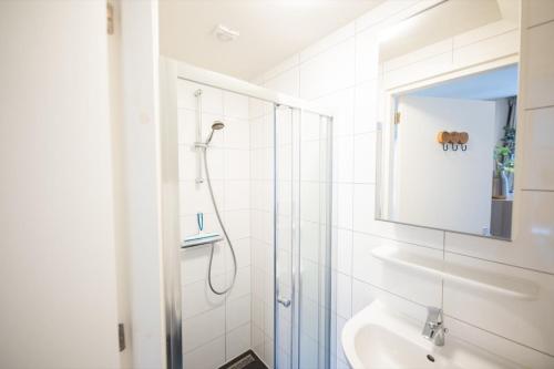 La salle de bains blanche est pourvue d'une douche et d'un lavabo. dans l'établissement Delightful 2 Bedroom Apartment, à Eindhoven