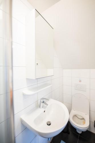 a white bathroom with a sink and a toilet at Delightful 2 Bedroom Apartment - SD23L in Eindhoven