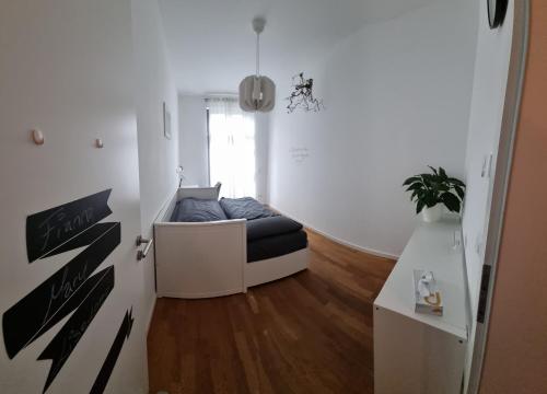 a living room with a couch in a white room at Helenas place in Berlin