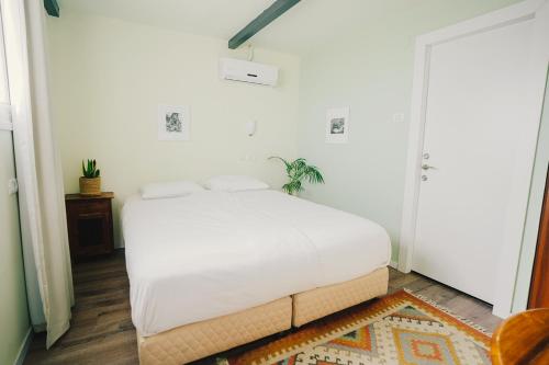 a bedroom with a white bed in a room at ibex unique Desert Inn in Mitzpe Ramon