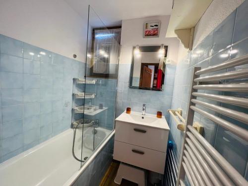 a bathroom with a sink and a shower and a tub at Appartement Les Saisies, 2 pièces, 5 personnes - FR-1-293-196 in Les Saisies