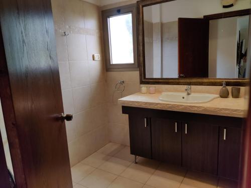 uma casa de banho com um lavatório e um espelho em וילה על ההר em Poriyya