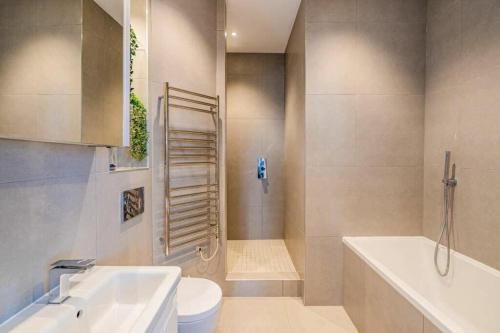 ein Badezimmer mit einer Badewanne, einem WC und einem Waschbecken in der Unterkunft easyStay Bath Road Slough in Slough