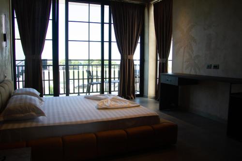 een slaapkamer met een bed en een groot raam bij Posh Villas in Rrogozhinë