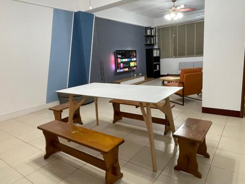 stół i ławki w pokoju z telewizorem w obiekcie Mountain Beyond Guest House w Jinhu