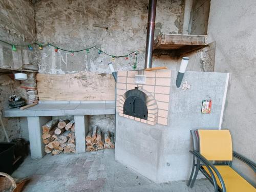 un horno de ladrillo con una mesa y un montón de madera en La Ferme, en Chambles