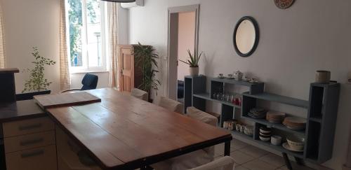- une salle à manger avec une table en bois et un miroir dans l'établissement Vue verte, à Bize-Minervois