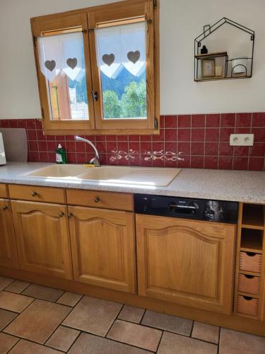 a kitchen with wooden cabinets and a sink and a window at La petite Anfiane in Le Grand-Bornand