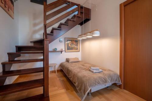 a bedroom with a bed and a spiral staircase at [Apartment near Perugia] - Free Parking & A/C in Badiola