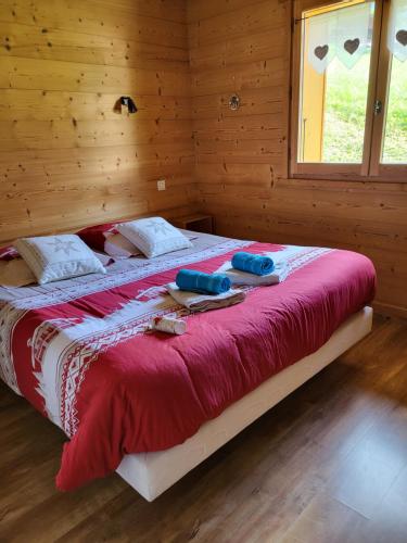 un letto in una camera di legno con due asciugamani di La petite Anfiane a Le Grand-Bornand