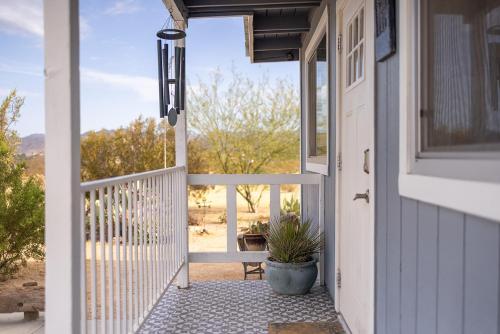 a porch with a door and a potted plant at The Raven House - Renovated Homestead Cabin in Joshua Tree
