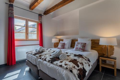 a bedroom with a large bed with red curtains at Géraniums Et Neige Fraîche, Maison d'Hôtes avec Suites Haut de Gamme, Balnéo massante et Sauna privés in Métabief