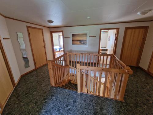 a room with a wooden staircase in a house at Rom 4 i bufellesskap in Sogndal