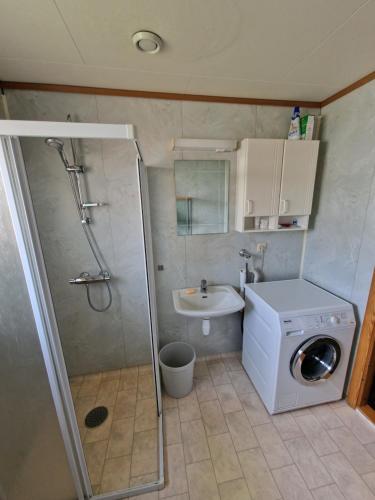 a bathroom with a shower and a washing machine at Rom 4 i bufellesskap in Sogndal