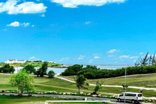 a white van driving down a road near the water at Luxury Oceanview 1BR on beach in Cupecoy