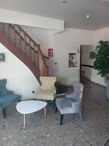 una sala d'attesa con sedie, tavolo e scale di hotel restaurant le saint nazaire a Saint-Nazaire-en-Royans