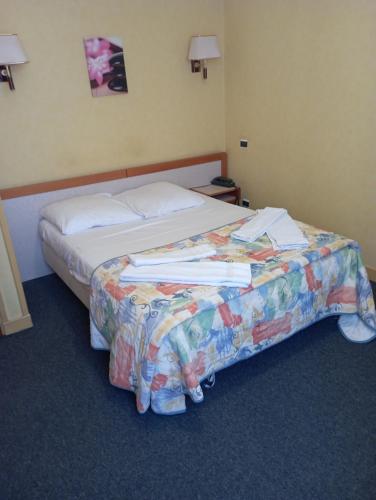 una camera d'albergo con un letto e dei libri sopra di hotel restaurant le saint nazaire a Saint-Nazaire-en-Royans