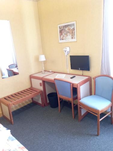 Cette chambre comprend un bureau avec un ordinateur et deux chaises. dans l'établissement hotel restaurant le saint nazaire, à Saint-Nazaire-en-Royans