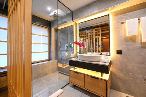 y baño con lavabo y ducha acristalada. en Hanami Design Hotel en Belgrado