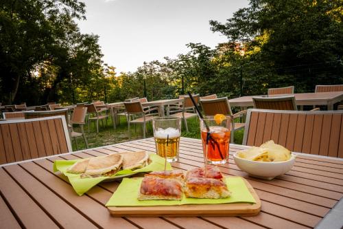 einen Tisch mit einem Teller Essen und zwei Gläsern Bier in der Unterkunft Borgo dei Sassi di Roccamalatina - Room and Breakfast in Rocca Malatina