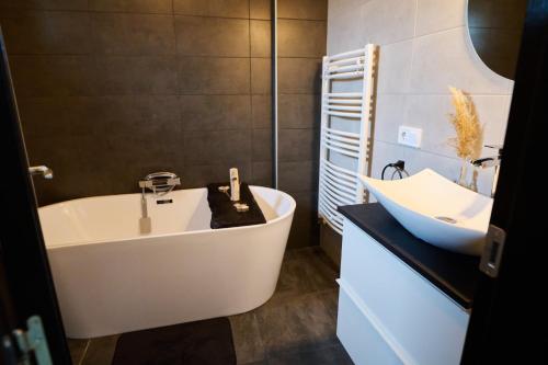 y baño con bañera blanca y lavamanos. en RDT Guest House-Rai din Transilvania, en Moieciu de Jos