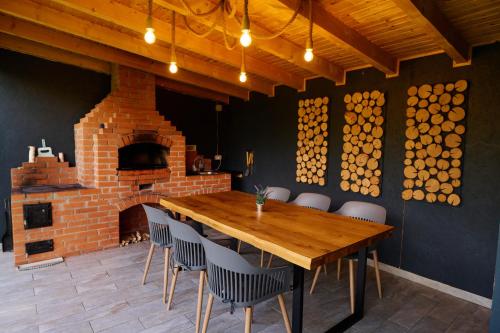 a dining room with a wooden table and a brick oven at RDT Guest House-Rai din Transilvania in Moieciu de Jos