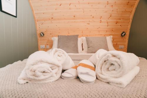 a bed with towels and slippers on it at Eastfield Glamping Farm in Spennithorne