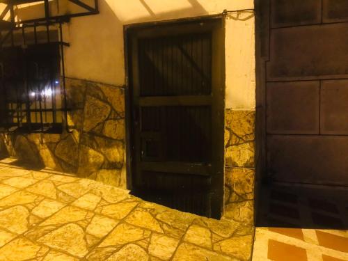 an open door on a building with a stone wall at la muñeca apartamento in Pereira